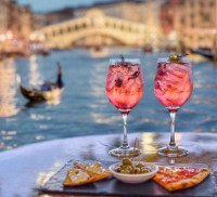 pink aperitif and appetizers with the Grand Canal in Venice in the background