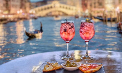 Pink aperitif and appetizers with the Grand Canal in Venice in the background