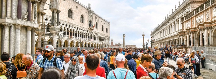 The visible effects of overtourism as cruise ship passengers crowd the walkway at the Doge's Palace in Piazza San Marco on a busy day in Venice, Italy